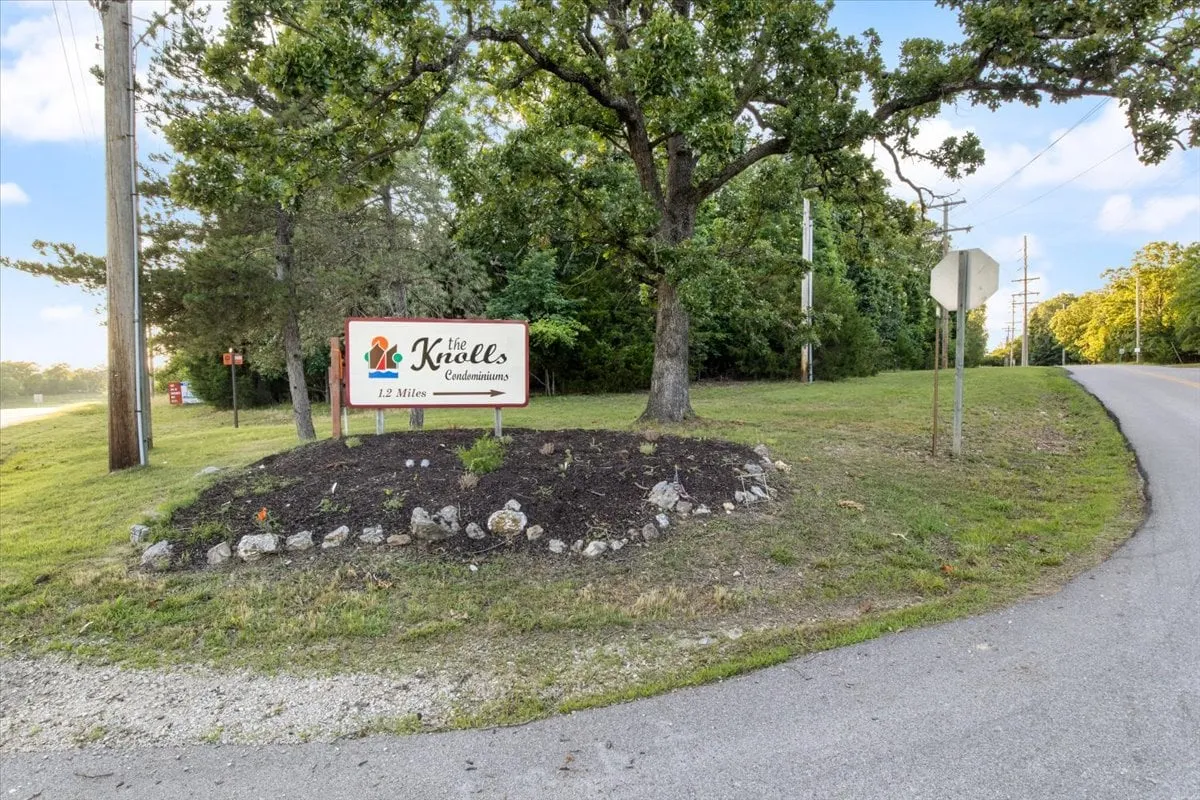 This image features the inviting entrance signage to the community, framed by mature trees and well-kept landscaping. The atmosphere is welcoming and sets a positive first impression for guests arriving at Knolls Haven.